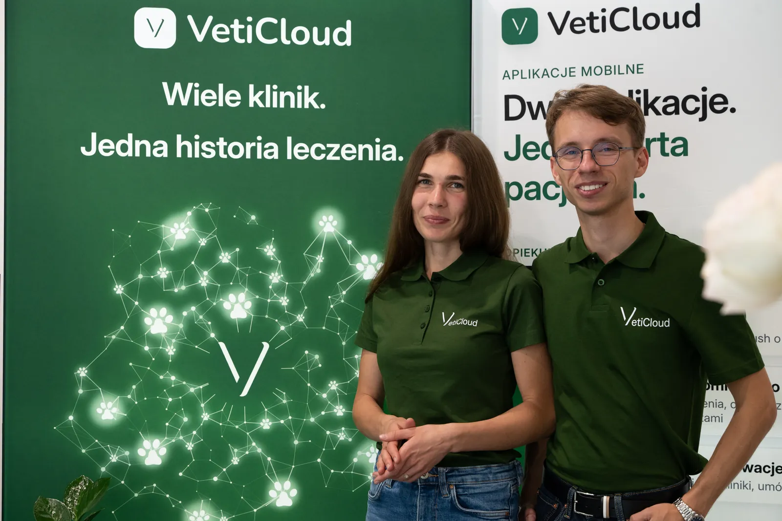 Zespół VetiCloud przed zieloną ścianą stoiska z hasłem „Wiele klinik. Jedna historia leczenia.”